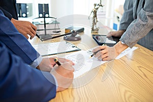 Businessmen and investors sign contract in front of company legal advisor and witness contract for their real estate investment.