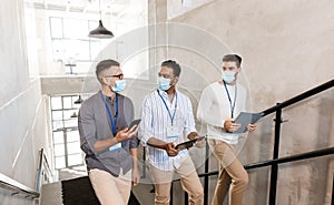 businessmen in masks with name tags going upstairs