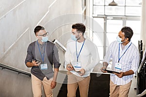 businessmen in masks with name tags going upstairs