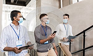 businessmen in masks with name tags going upstairs