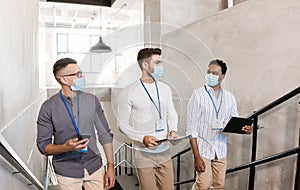 businessmen in masks with name tags going upstairs