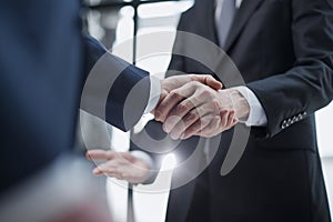 businessmen meeting and handshake in front of business center buildings