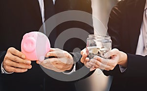 Businessmen, men and women holding a piggy bank, coins to save m