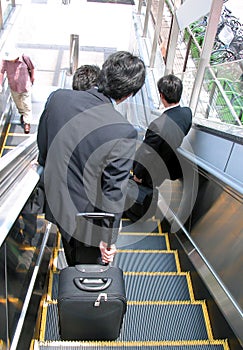 Businessmen on moving staircase