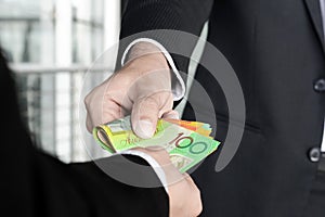 Businessmen passing money, Australia dollar banknotes