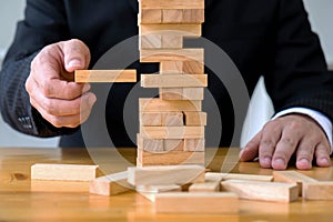 Businessmen picking dominoe blocks to fill the missing dominoes. Growing business concept