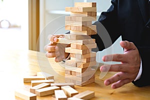 Businessmen picking dominoe blocks to fill the missing dominos a photo