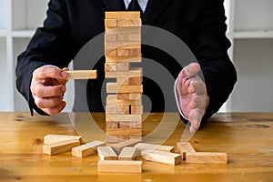 Businessmen picking dominoe blocks to fill the missing dominos and protect domino to fail. Growing business concept