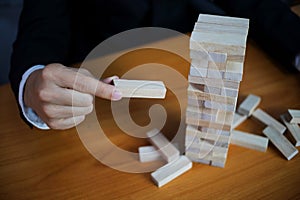 Businessmen picking wood blocks to fill the missing dominoes. Growing business concept