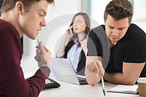 Businessmen Planning While Colleague Using Smart Phone