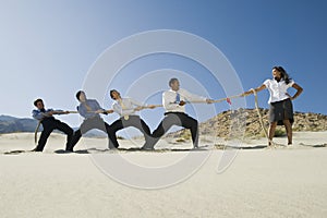 Businessmen Playing Tug Of War Against One Woman