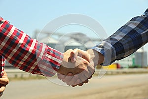 Businessmen shake hands against silos Agriculture business