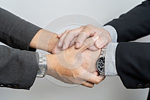 Businessmen shake hands, end of meeting, business concept. Two happy businessman handshake over the desk during meeting