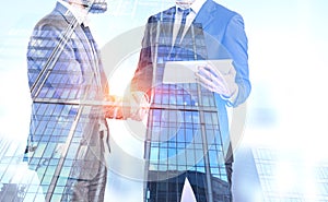Businessmen shake hands, skyscrapers