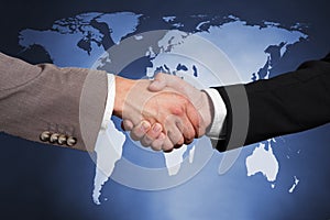 Businessmen shaking hands against worldmap