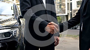 Businessmen shaking hands in agreement, meeting outdoors, informal lobbying
