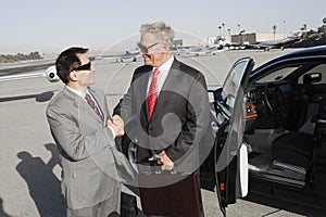 Businessmen Shaking Hands At Airfield photo