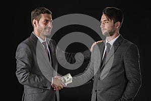 Businessmen shaking hands with dollar banknotes