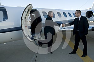 Businessmen shaking hands in front of corporate je