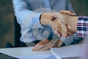 Businessmen shaking hands and meeting as a team, hiring or partnering at the office. Closeup of employees shaking hands