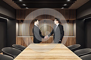 Businessmen shaking hands in meeting room