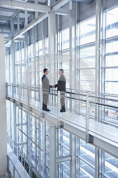 Businessmen Shaking Hands In Modern Office