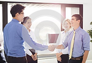 Businessmen Shaking Hands In Office