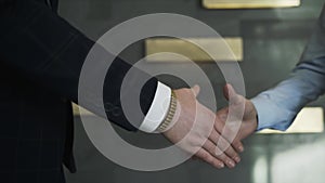 Businessmen shaking hands in the office, closeup. Action. Good deal, business concept, two men shaking hands on the