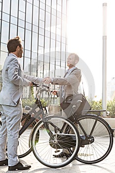 Businessmen shaking hands outside office building