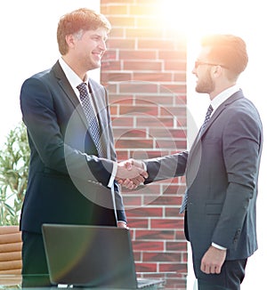 Businessmen shaking hands while standing in office corridor