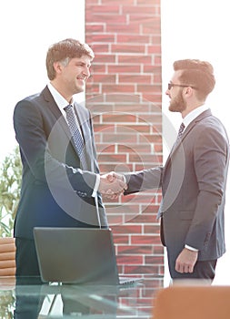 Businessmen shaking hands while standing in office corridor