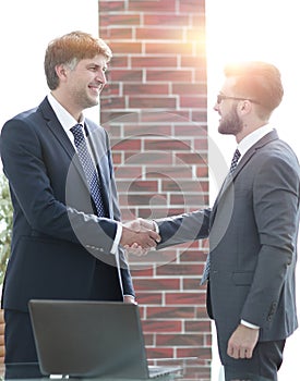 Businessmen shaking hands while standing in office corridor