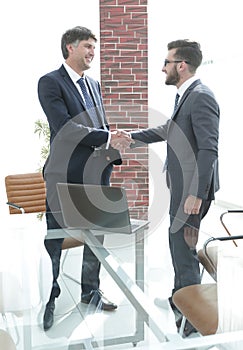 Businessmen shaking hands while standing in office corridor