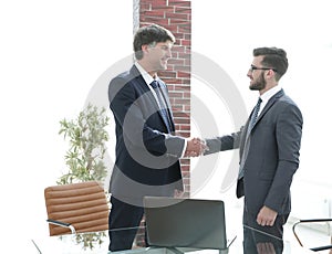 Businessmen shaking hands while standing in office corridor