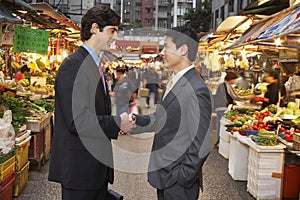 Businessmen Shaking Hands At Street Market