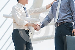 Businessmen shaking hands with with success gesture in modern city. Focus hand