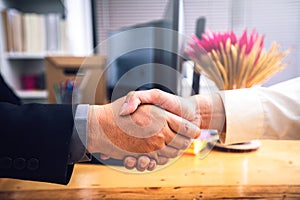 Businessmen shaking hands After successfully completing the investment and life insurance contract at office