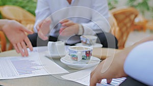 Businessmen sit at a table and discuss the financial moments