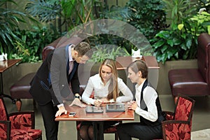 Businessmen sitting in cafe for a laptop. two girls