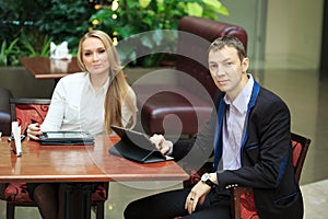 Businessmen sitting in cafe for a laptop. two girls