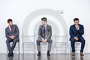 Businessmen sitting in queue and waiting for interview in office