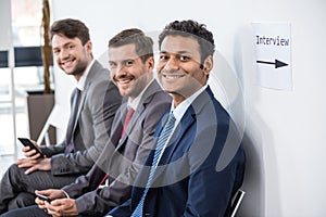 Businessmen sitting in queue and waiting for interview in office