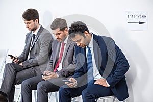 Businessmen sitting in queue and waiting for interview in office