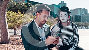 Businessmen, smartphone and typing with street mime in downtown to search location or navigate New York. Entrepreneur