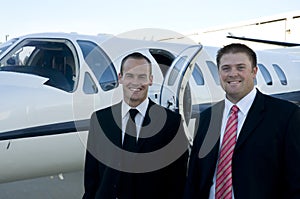 Businessmen standing in front of corporate jet