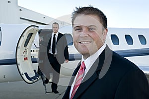 Businessmen standing in front of corporate jet