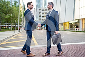 Businessmen in suit shaking hands outdoors. Handshake between two businessmen. wo business men had business contacts