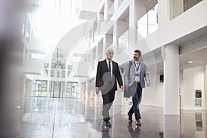 Businessmen Talking As They Walk Through Office Lobby photo