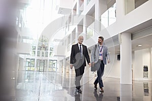 Businessmen Talking As They Walk Through Office Lobby