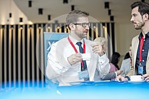 Businessmen talking during coffee break at lobby of convention center